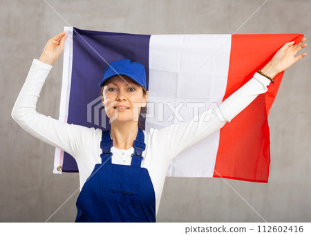Smiling adult woman in uniform holding France flag 112602416