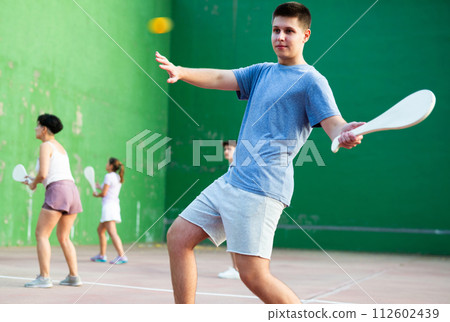 Young man playing Basque pelota on outdoor pelota court Young man playing Basque pelota on outdoor pelota court 112602439