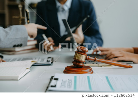 Justice and law concept. Team judge in a courtroom the gavel, working with digital tablet computer on table in sun light. Justice and law concept. Team judge in a courtroom the gavel, working with digital tablet computer on table in sun light. 112602534