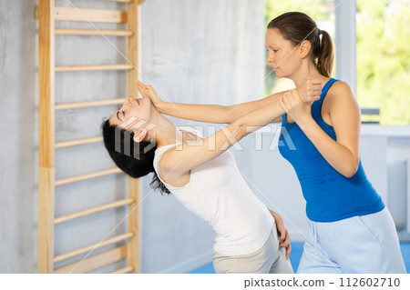 Woman doing a head kick during self defense training 112602710