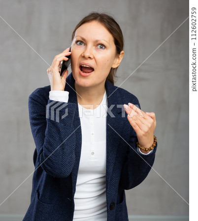Unhappy annoyed woman argues on phone with fury anger and frustration Unhappy annoyed woman argues on phone with fury anger and frustration 112602759