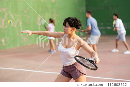 Woman playing frontenis on outdoor pelota court 112602812