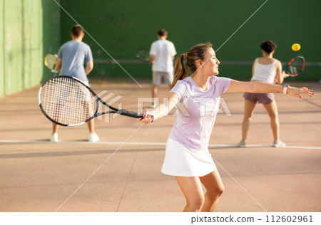 Young Argentinian woman playing frontenis at open-air fronton in summer 112602961
