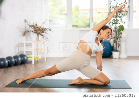 Experienced girl fitness club teacher performs deadbolt pose, parighasana Experienced girl fitness club teacher performs deadbolt pose, parighasana 112603012