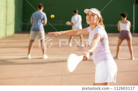 Woman Basque pelota player hitting ball with wooden racket Woman Basque pelota player hitting ball with wooden racket 112603117