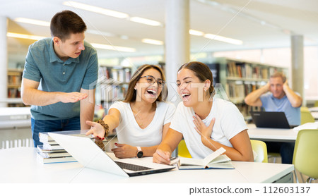 Young annoyed male interrupts noisy female students Young annoyed male interrupts noisy female students 112603137