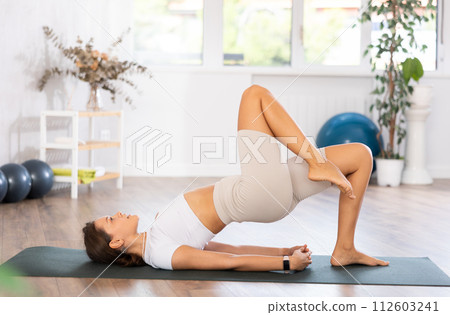 Fit young woman doing pilates yoga exercise fitness training workout. Physical activity for body and mind relaxation, healthy lifestyle habits concept 112603241