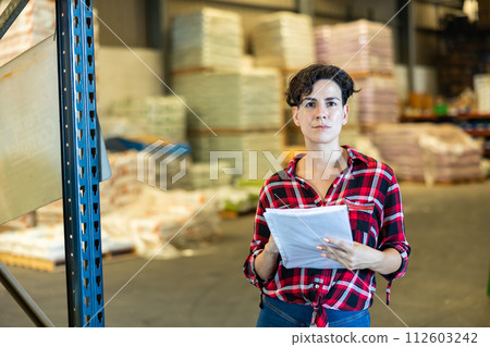 Female storekeeper checks presence of goods in the building materials warehouse 112603242