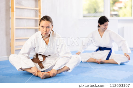Karate athletes practice butterfly stretch Karate athletes practice butterfly stretch 112603307