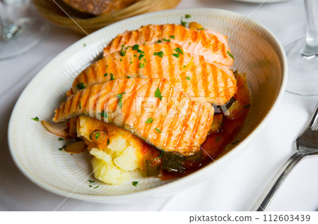 Salmon on the grill, marinated in sauce, dill, salt, pepper and a few drops of lemon 112603439