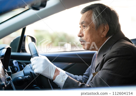 Senior male driver sideways Senior male driver sideways 112604154