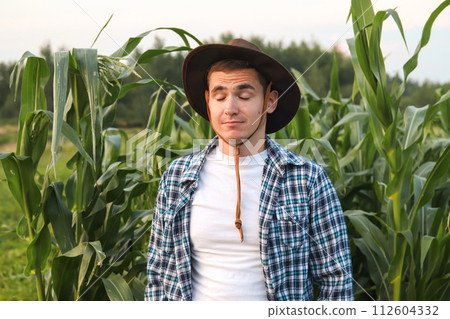 Young farmer closed eyes. Tired farmer. Tired young farmer depicted with eyes closed, reflecting the challenges of agricultural work 112604332