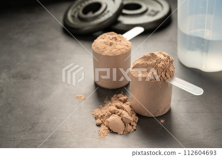 Chocolate protein powder in scoops. Food supplement, nutrition  112604693