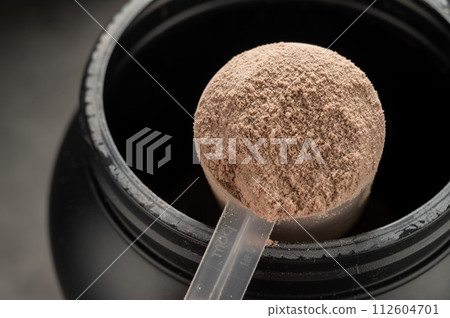 Chocolate protein powder in scoop. Food supplement, nutrition Chocolate protein powder in scoop. Food supplement, nutrition 112604701