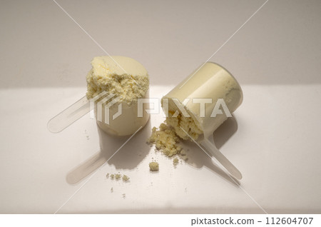 Vanilla protein powder in scoops. Food supplement, nutrition Vanilla protein powder in scoops. Food supplement, nutrition 112604707