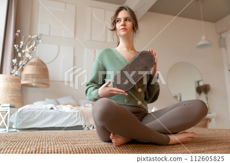 a young lady takes sadhu nail board on hands, preparing to practice on nails 112605825