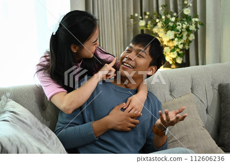 Cheerful young woman embracing her husband from the back on bed. Love, relationship and lifestyle concept 112606236