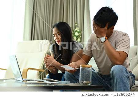 Unhappy young couple calculating family spends together and feeling depressed 112606274