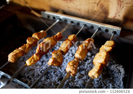 Summer Barbecue at Home Featuring Kebabs Grilling in a Backyard Grill 112606528