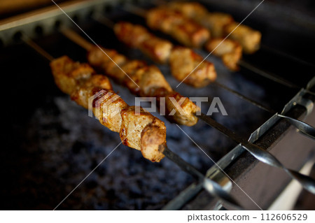 Summer Barbecue at Home Featuring Kebabs Grilling in a Backyard Grill Summer Barbecue at Home Featuring Kebabs Grilling in a Backyard Grill 112606529