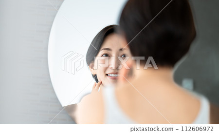 Woman looking in the mirror Woman looking in the mirror 112606972