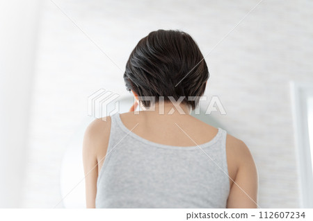 Rear view of a woman looking in the mirror 112607234