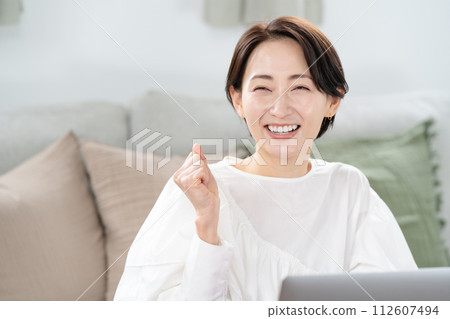 一個女人看著電腦,揮舞著拳頭 一個女人看著電腦,揮舞著拳頭 112607494
