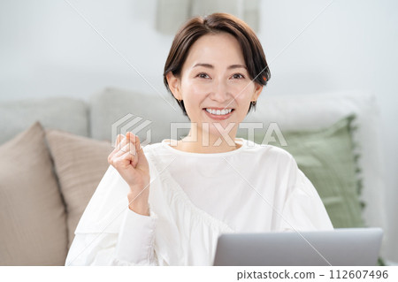 一個女人看著電腦，揮舞著拳頭 112607496