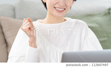 一個女人看著電腦，揮舞著拳頭 112607497