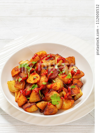fried spanish potatoes with paprika sauce in bowl fried spanish potatoes with paprika sauce in bowl 112608532