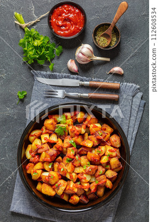 fried spanish potatoes with paprika sauce in bowl fried spanish potatoes with paprika sauce in bowl 112608534