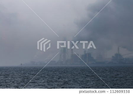 The sea on a rainy day and a group of factories on the opposite shore The sea on a rainy day and a group of factories on the opposite shore 112609338