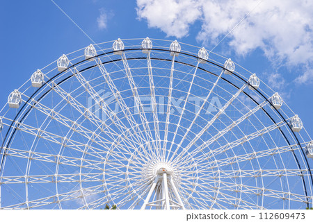 Ferris wheel in white color against summer blue sky 112609473
