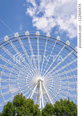 Ferris wheel in white color against summer blue sky Ferris wheel in white color against summer blue sky 112609474