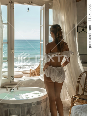 A girl with long hair standing next to the blind and opening the curtain with beautiful view of blue ocean, accommodation with ocean view with tropical weather, honeymoon, hotel room with sea view A girl with long hair standing next to the blind and opening the curtain with beautiful view of blue ocean, accommodation with ocean view with tropical weather, honeymoon, hotel room with sea view 112609990