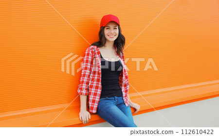 Summer portrait of happy smiling young woman posing in red baseball cap, casual clothes 112610422