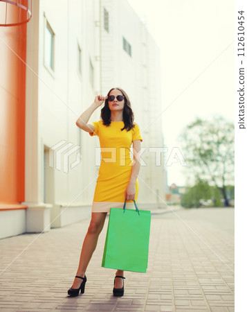 Stylish beautiful young woman full-length posing with shopping bags in the city Stylish beautiful young woman full-length posing with shopping bags in the city 112610454