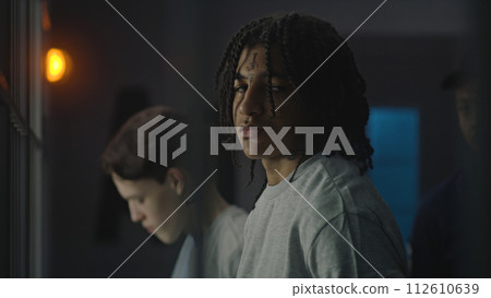 African American teenager stands near prison cell, looks at the camera African American teenager stands near prison cell, looks at the camera 112610639