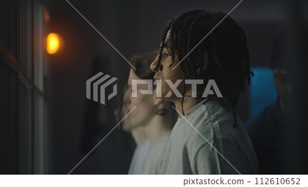 African American teenager stands near prison cell, looks at the camera 112610652