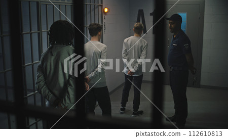Group of prisoners stand near jail cell, warden talks with them Group of prisoners stand near jail cell, warden talks with them 112610813