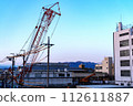 Heavy equipment at the construction site and surrounding buildings 112611887