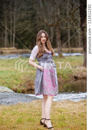 Spring magic in a dirndl Woman enjoying nature in a meadow Spring magic in a dirndl Woman enjoying nature in a meadow 112612292