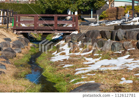 A snowy stream between roadside stations 112612781