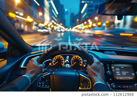Pov shot of hands on steering wheel driving down urban street at night 112612908