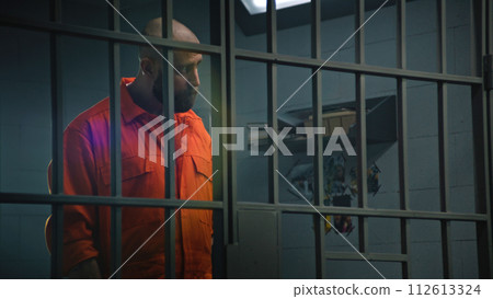 Prisoner in orange uniform talks with advocate and reads contract 112613324