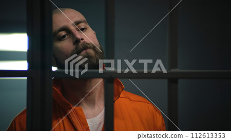 Criminal in orange uniform talks with lawyer and reads contract Criminal in orange uniform talks with lawyer and reads contract 112613353
