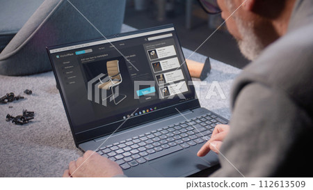 Small business owner uploads pictures of wooden chair to online store 112613509