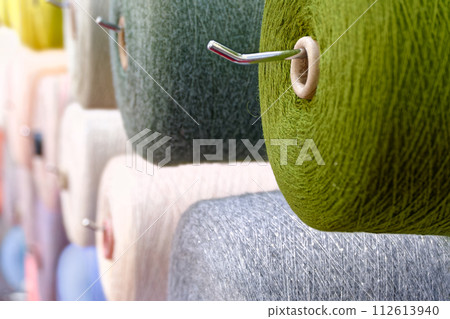 Assorted spools of multi-colored wool threads 112613940