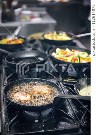 Cooking meat in a frying pan 112614076