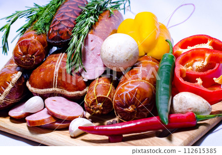 Tasty sausages and vegetables isolated over solid background Tasty sausages and vegetables isolated over solid background 112615385